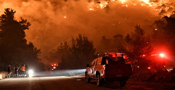 Flames rise as firefighters and volunteers try to extinguish a fire burning in the village of Schinos, Greece. 19 May 2021. REUTERS/Vassilis Psomas
